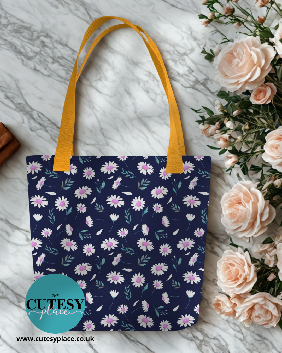 Floral tote bag with yellow handle on a marble surface with flowers